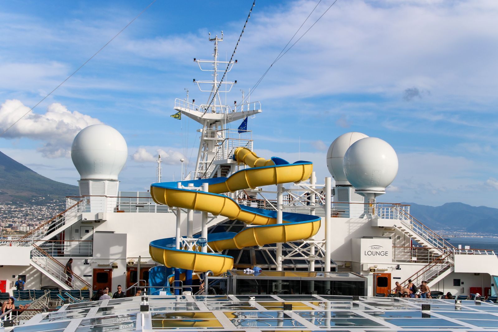 Yellow and blue waterslide winding down the top deck of a family cruise ship, the kind of sailing kids sail free cruises are offered on
